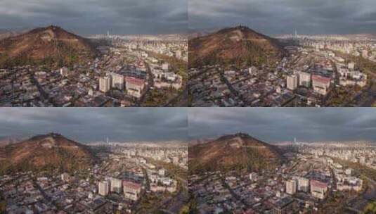 智利日落时圣地亚哥北部城市的塞罗圣克里斯托瓦尔。空中广角拍摄高清在线视频素材下载