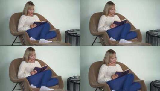 漂亮女人白天坐在家里的扶手椅上看书，做梦和享受高清在线视频素材下载