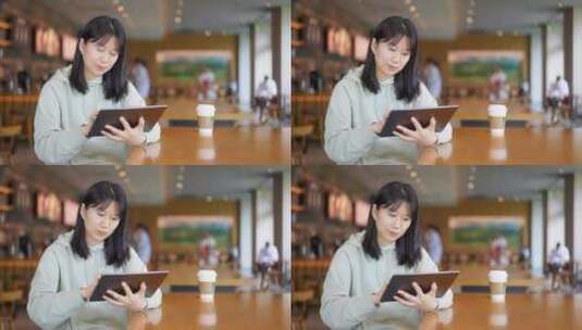 年轻女子在图书馆使用平板电脑高清在线视频素材下载
