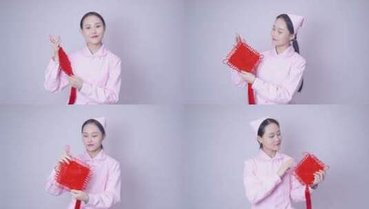 年轻女护士装手持中国结高清在线视频素材下载