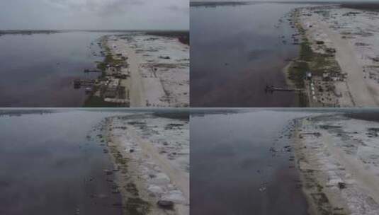 一架无人驾驶飞机沿着达喀尔粉色湖岸移动，显示了盐堆和船高清在线视频素材下载