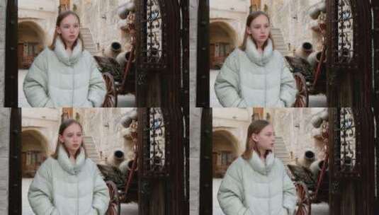 女孩站在老城区的门口高清在线视频素材下载