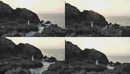 孤独的美女在海边黑礁石上翩翩起舞高清在线视频素材下载