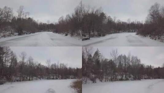 森林中的冬天，相机在白天飞过结冰的河流高清在线视频素材下载