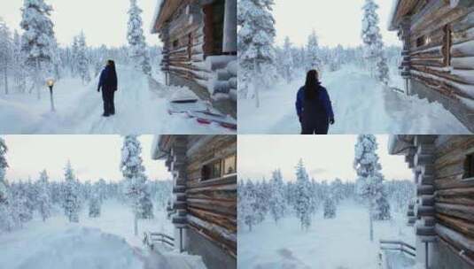 女孩眺望雪景，站在芬兰拉普兰的小屋旁，北高清在线视频素材下载