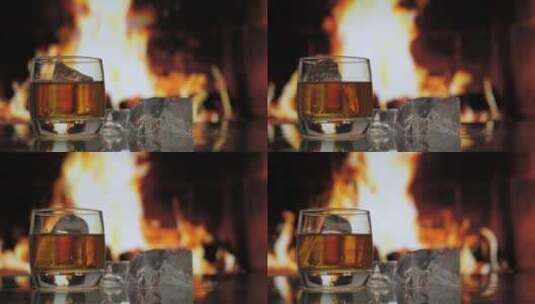 一杯加冰的威士忌放在桌子上，背景是火焰壁高清在线视频素材下载