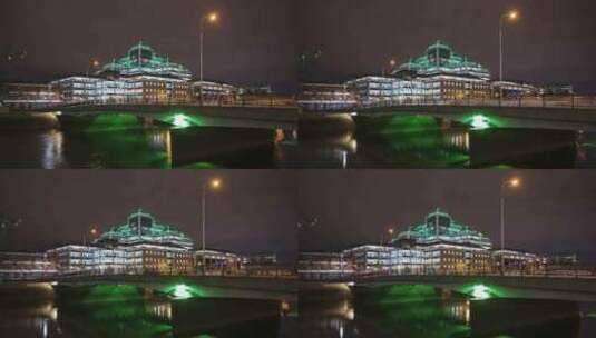 阿尔斯特银行大楼的时间推移在晚上被利菲河上桥梁上的交通照亮高清在线视频素材下载