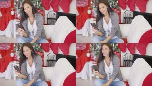 圣诞树旁看手机的女孩高清在线视频素材下载