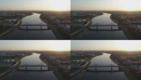 日落时分横跨河流的公路桥鸟瞰图。美丽的城市景观高清在线视频素材下载