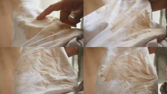 妇女手持白色脏衬衫展示制造污渍高清在线视频素材下载