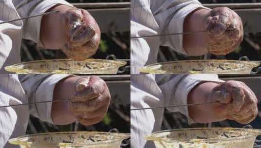 胖子把腌制的生肉放在串上做烤肉串高清在线视频素材下载