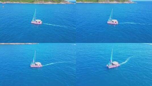 海南三亚高视角航拍蔚蓝色大海与行驶的帆船高清在线视频素材下载