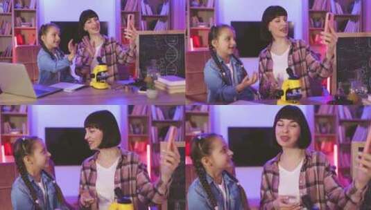 迷人的女人和小女孩使用手机视频流科学博客高清在线视频素材下载