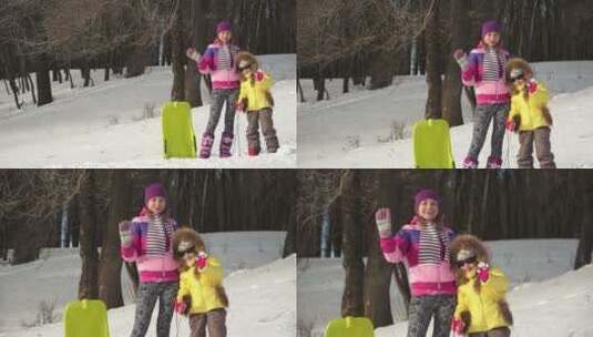 雪山上的母女在镜头前挥手微笑高清在线视频素材下载