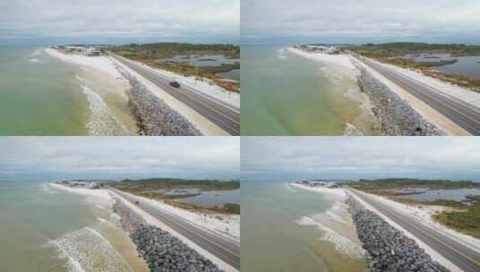 佛罗里达州圣布拉斯角，海浪撞击岩石屏障，空中拉离公路高清在线视频素材下载