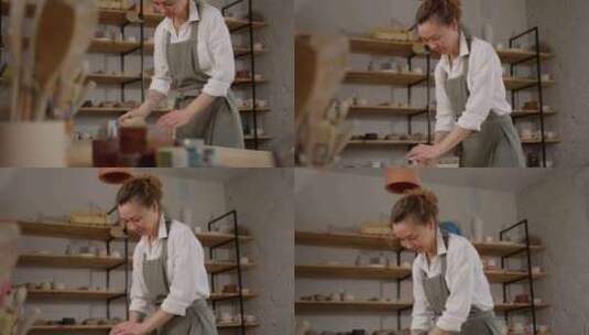 围裙上的女工匠在一个舒适的陶瓷车间里快乐高清在线视频素材下载
