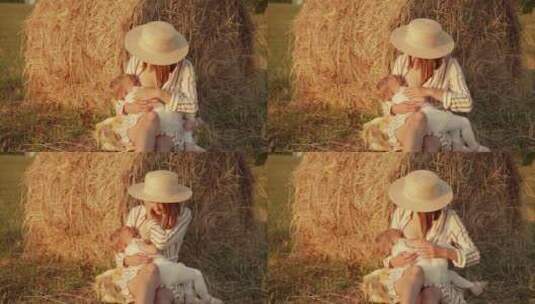 母亲在村子附近的田野里给婴儿喂奶高清在线视频素材下载