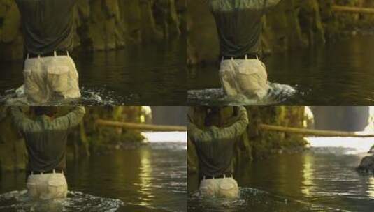 一个男人举着包裹慢慢走进河水深处高清在线视频素材下载