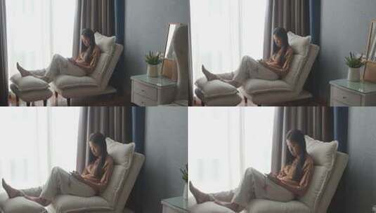 女子在室内沙发上休闲阅读高清在线视频素材下载