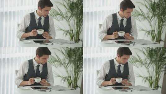 男人坐在桌旁看报纸喝咖啡高清在线视频素材下载