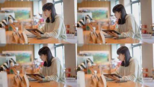 年轻女子在咖啡店使用平板电脑上网高清在线视频素材下载