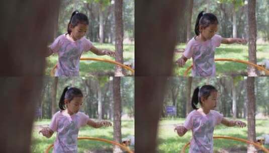 在树林中玩呼啦圈的东方女孩高清在线视频素材下载