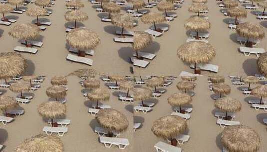 沙滩伞和日光浴浴床的鸟瞰图高清在线视频素材下载