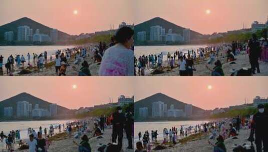 三亚大东海景区沐浴在夕阳余晖下的游客市民高清在线视频素材下载