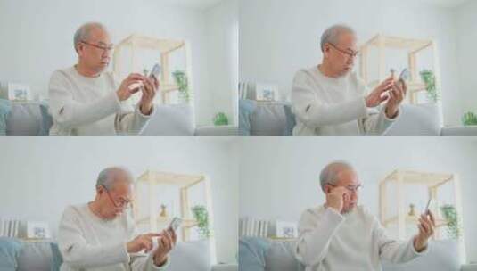 亚洲老年男性在家中客厅使用手机。高清在线视频素材下载
