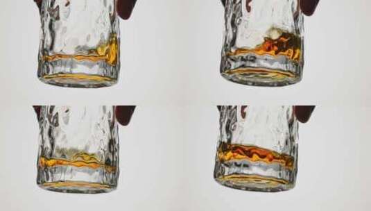 玻璃酒杯里的威士忌金黄色酒液摇晃高清在线视频素材下载