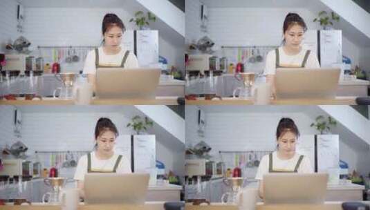 年轻女性烘培师在厨房使用笔记本电脑高清在线视频素材下载