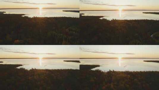 空中，被秋树环绕的偏远湖泊，远处地平线上的日落高清在线视频素材下载