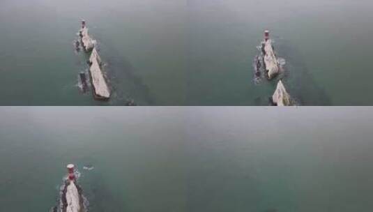 无人驾驶飞机飞越白色悬崖和红白相间的灯塔高清在线视频素材下载