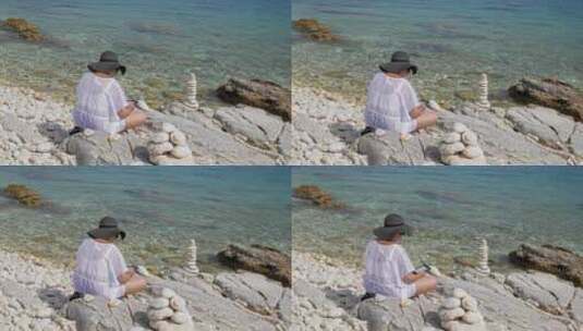 希腊帕拉利亚恩普利西石滩上坐着放松的女游客——静态拍摄高清在线视频素材下载