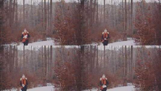在森林雪地里行走的女人高清在线视频素材下载