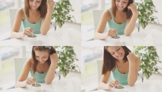 年轻女子坐在桌子旁搅拌咖啡微笑着对着镜头大笑高清在线视频素材下载