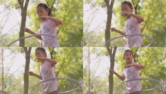在树林中玩呼啦圈的东方女孩高清在线视频素材下载
