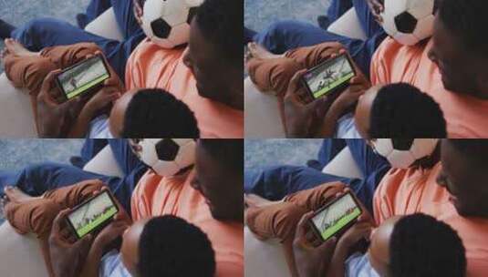 父子在家用智能手机看橄榄球比赛的照片高清在线视频素材下载