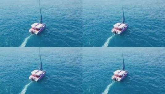 海南三亚高视角航拍蔚蓝色大海与行驶的帆船高清在线视频素材下载