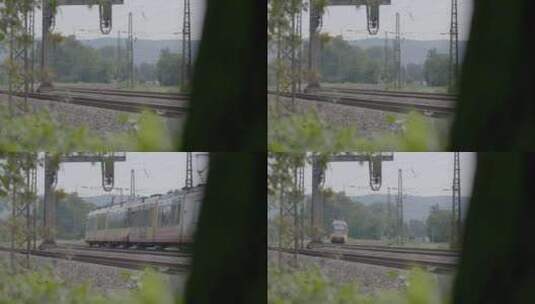 黄色和白色的火车在前景是绿色树叶的铁轨上高清在线视频素材下载