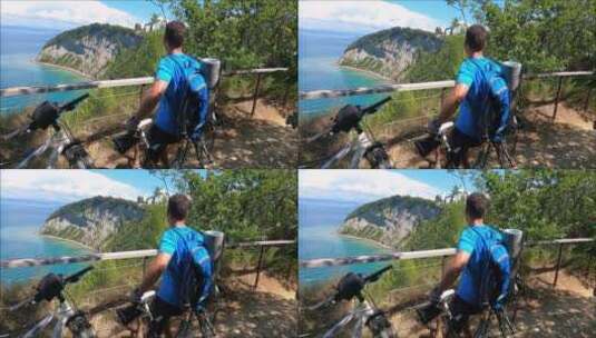 骑行者坐在山顶欣赏风景高清在线视频素材下载