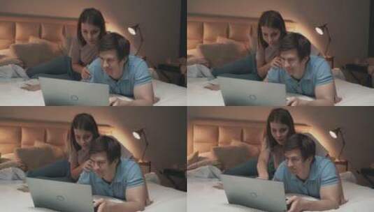情侣在床上一起看电脑高清在线视频素材下载