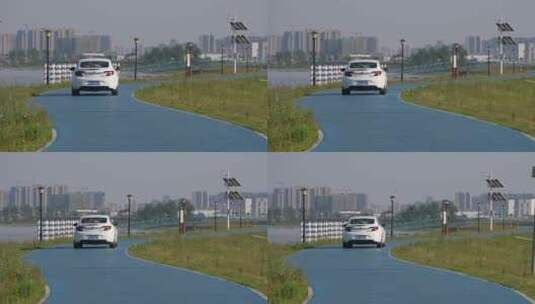 河堤上行驶的白色小轿车高清在线视频素材下载