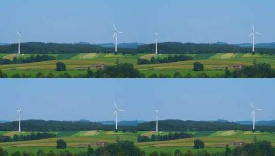 树林和农田间的风力发电机高清在线视频素材下载