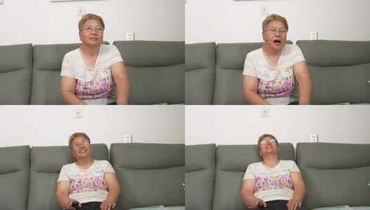 中老年女性沙发上手持遥控器高清在线视频素材下载