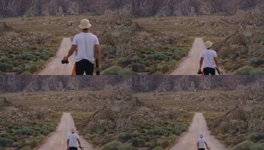 男人拿着相机向荒原上的小路走着高清在线视频素材下载