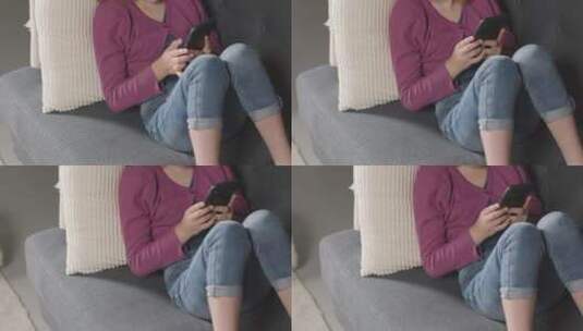 坐在沙发上玩手机的女人高清在线视频素材下载