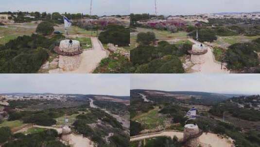 空中旋转拍摄的以色列国旗飘扬在以色列的一座石头纪念碑上，白天的Katzir高清在线视频素材下载