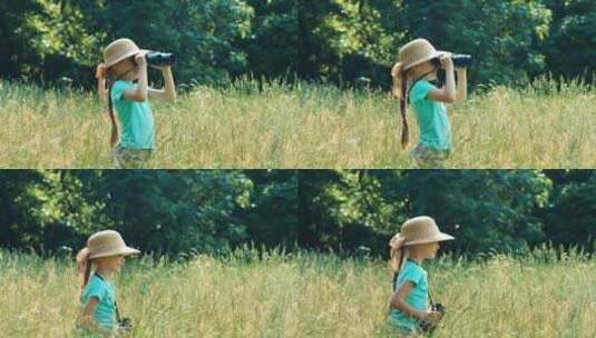 女孩站在高高的草地上透过望远镜四处观看高清在线视频素材下载