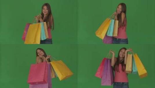 绿幕前女人开心的提着彩色购物袋高清在线视频素材下载